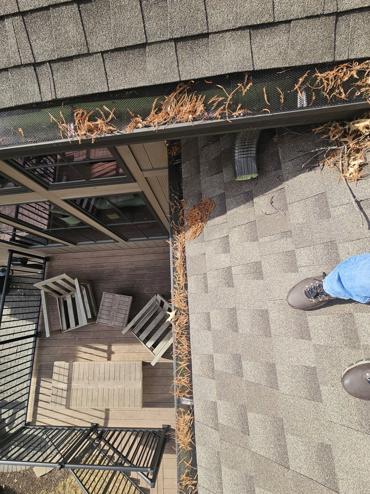 Organic buildup along a screened gutter section before service