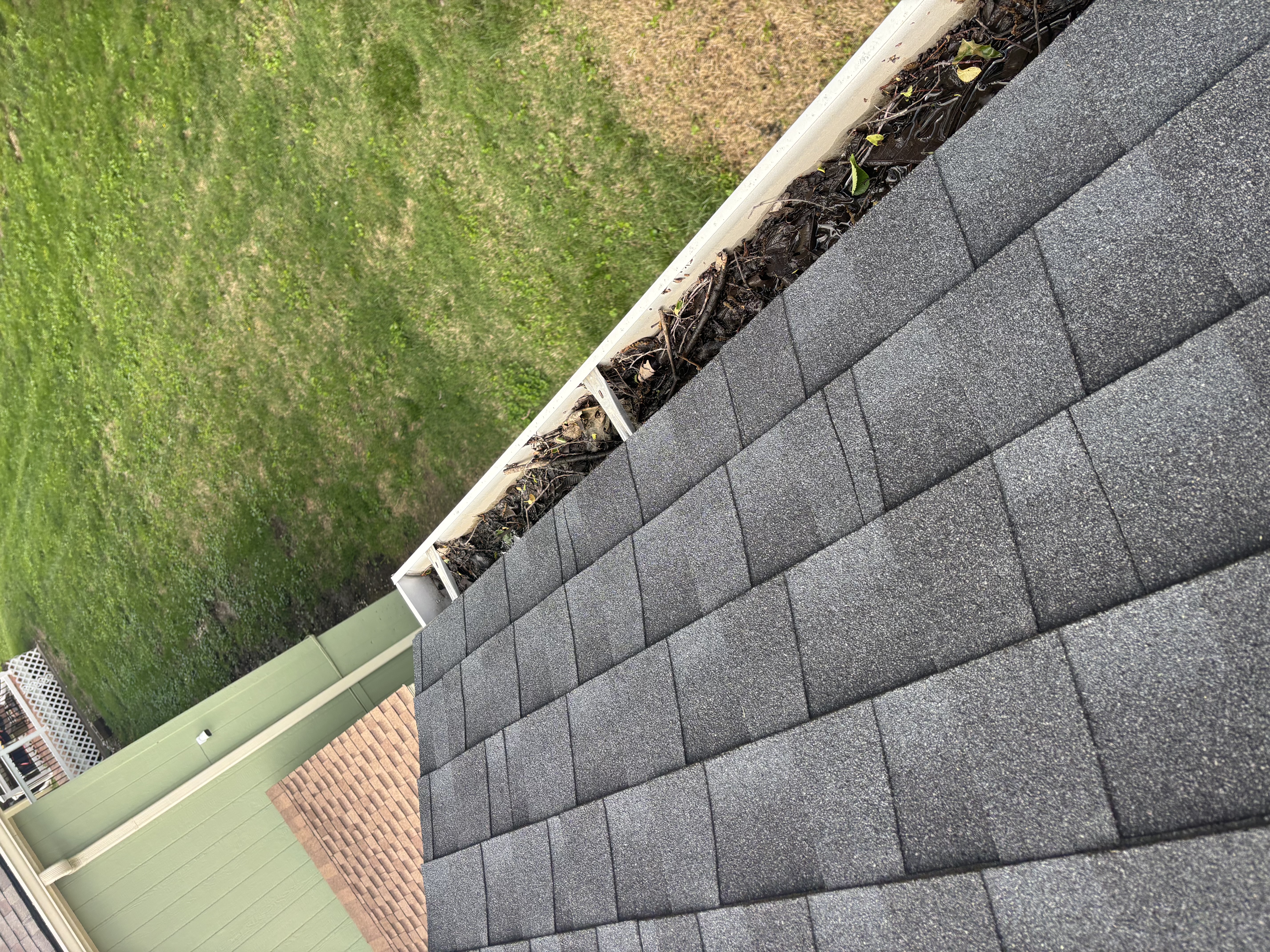 Packed debris in an open gutter on the Kansas City home before cleaning