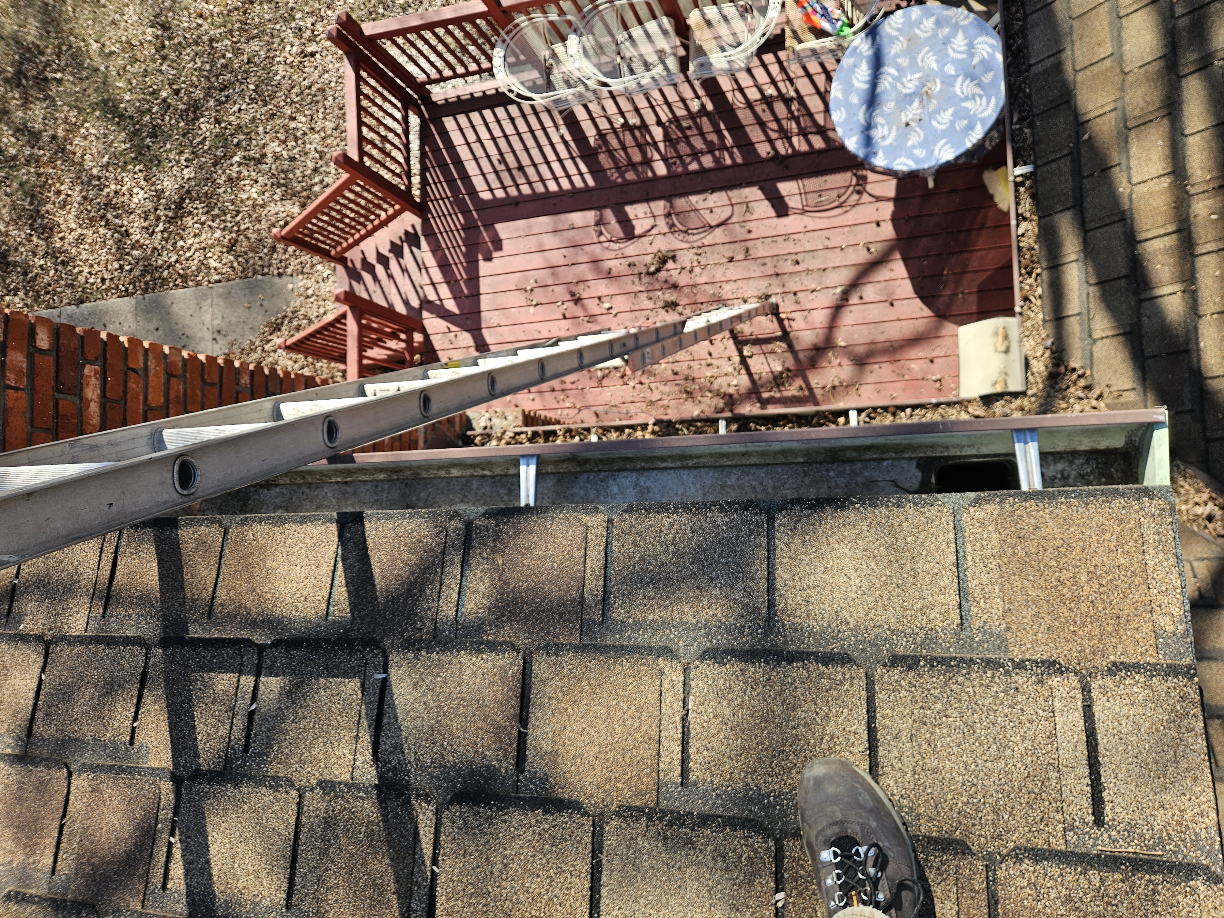 Deck-side upper gutter run after cleaning on a Kansas City home