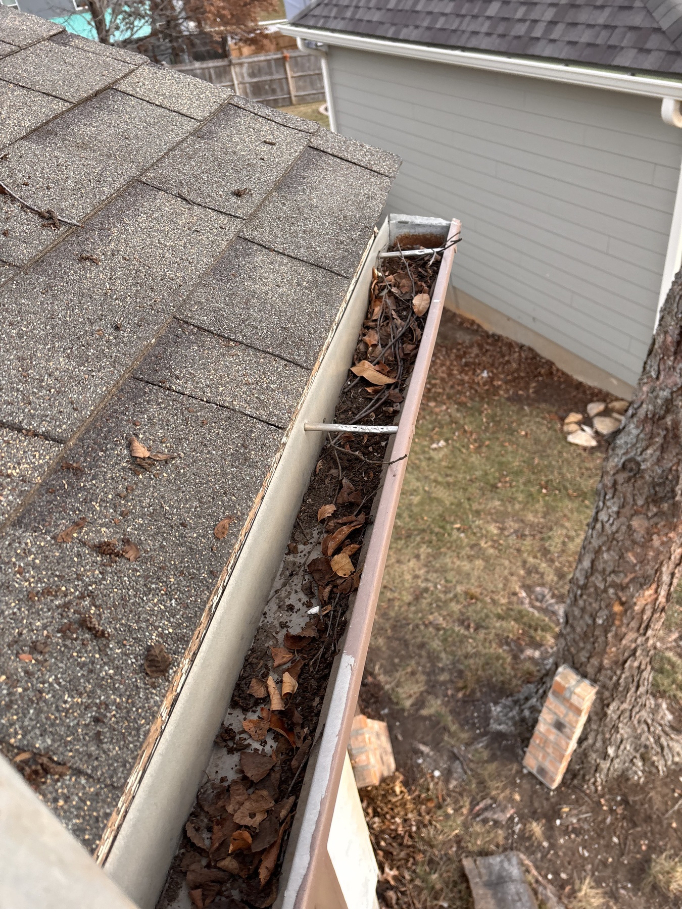 Longer gutter run showing debris before cleaning