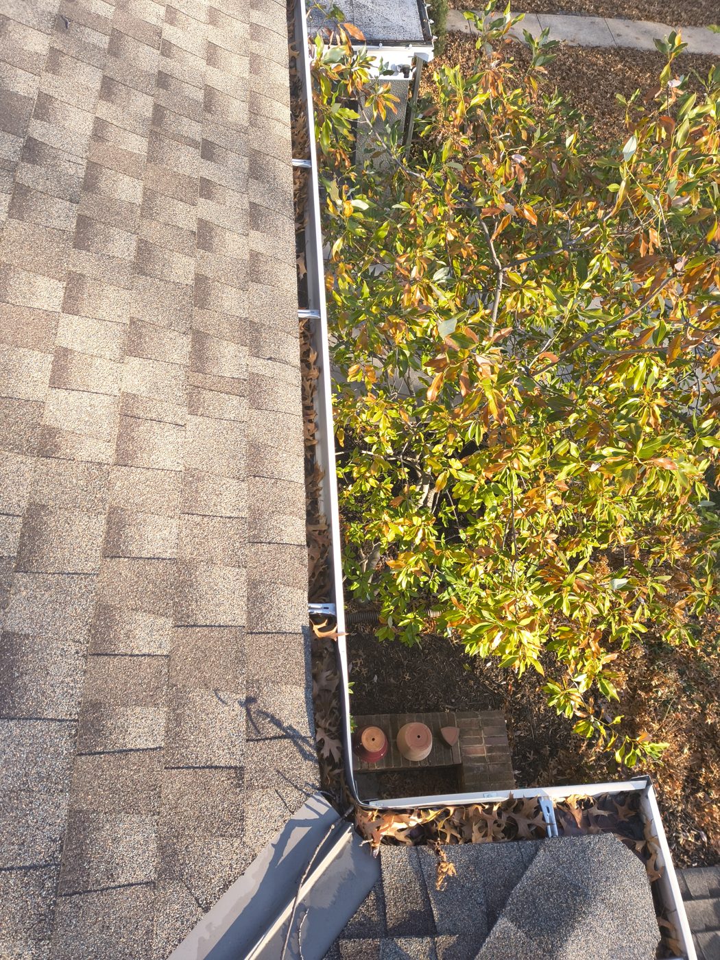 Debris inside the upper gutter run of a two-story Brookside-area home before cleaning