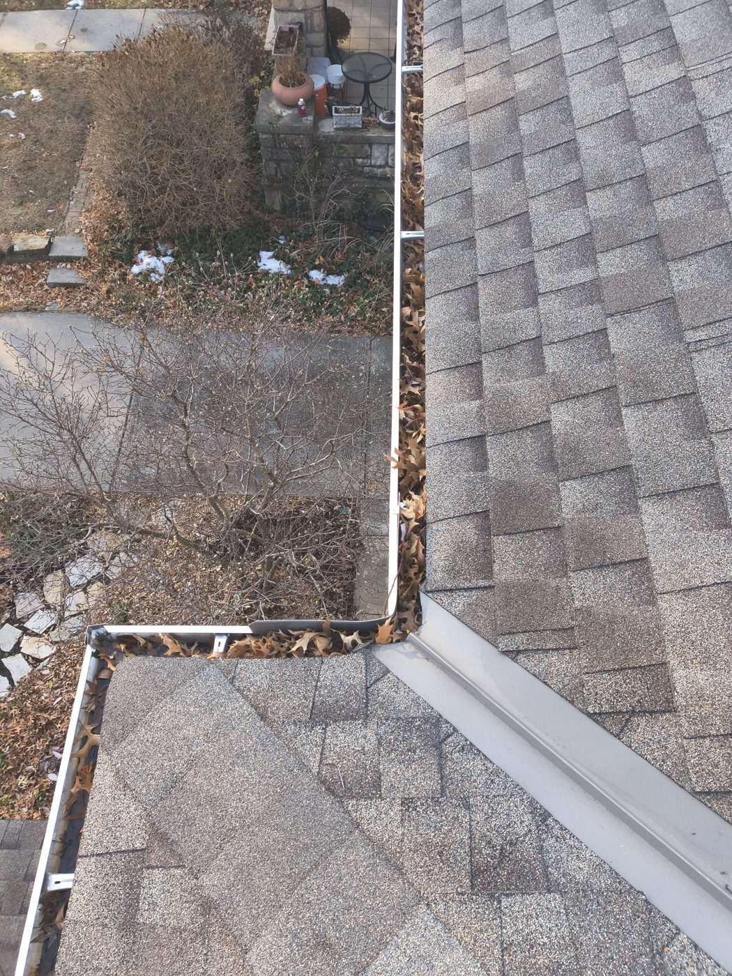 Organic buildup in an upper gutter corner before cleaning